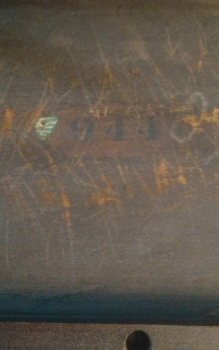 Markings on the bottom of a wooden table.