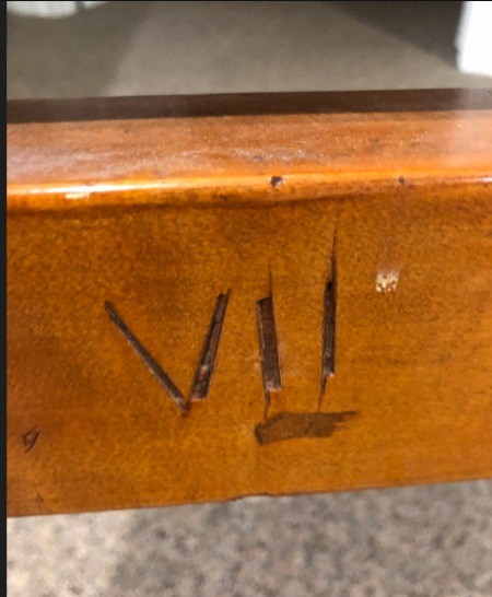 Marking on the inside of a wooden bedframe.
