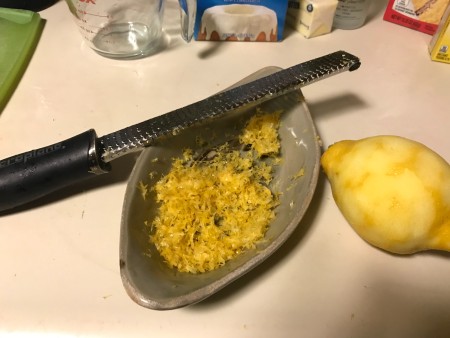 Finely zesting lemon peel.