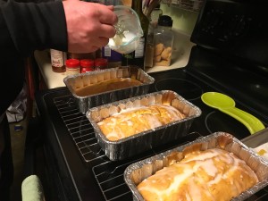 Drizzling icing and zest on top of the loaves.