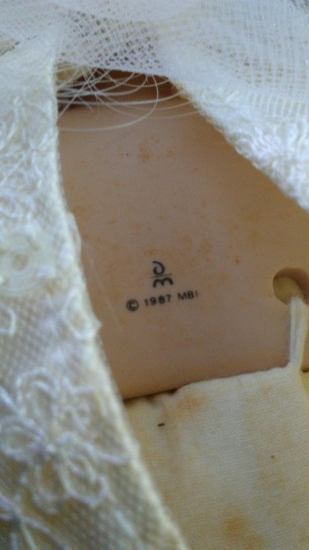 The markings on the neck of a porcelain doll.