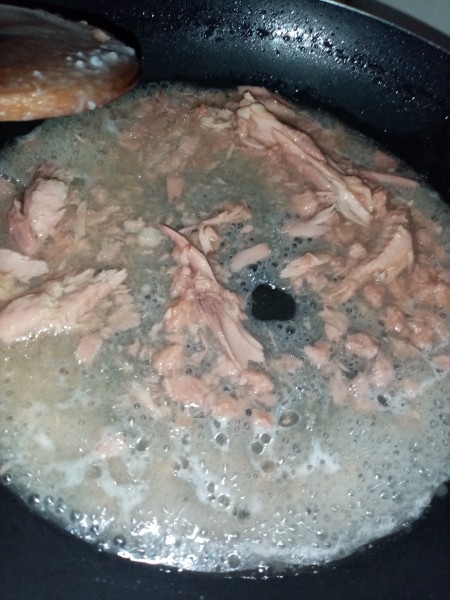 Adding tuna to the pan.