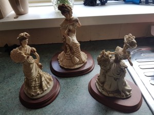 Three figurines of fancy ladies.