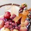 A fruit basket with apples and grapes.