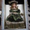 A doll in a shadowbox frame.