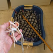 A clothes basket with strings attached for pulling.