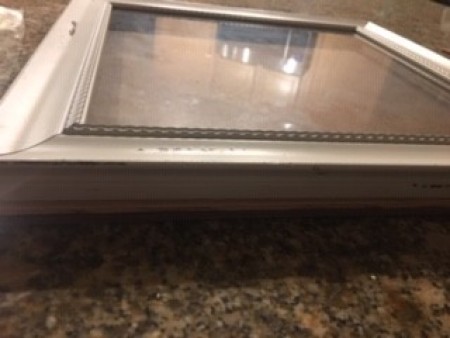 An empty wooden frame with glass.