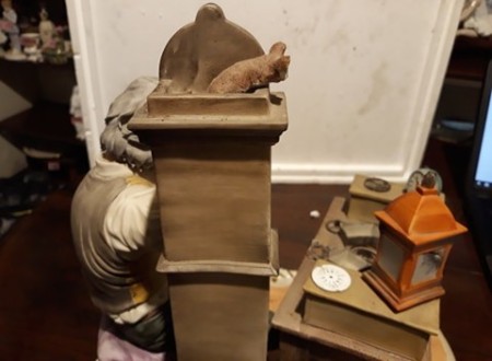 A figurine of a clock maker.