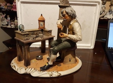 A figurine of a clock maker.