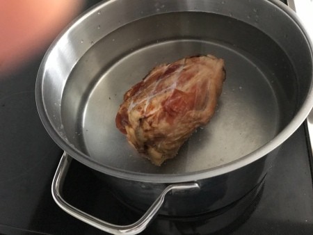 Cooking a ham hock in water to make broth.