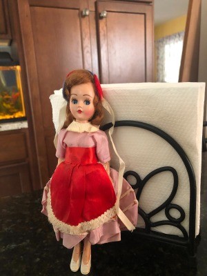 A plastic doll with a red dress.