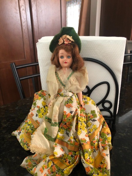 A doll with a fancy dress and hat.
