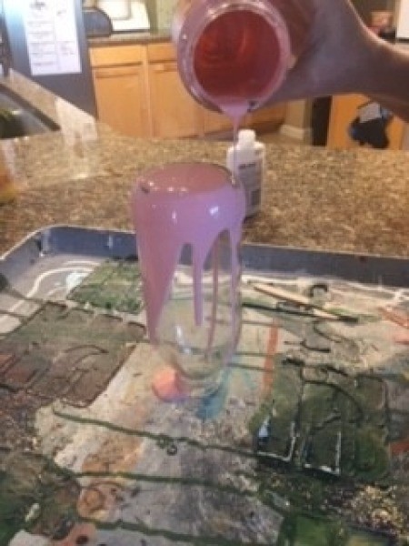 Pouring paint on the bottle.