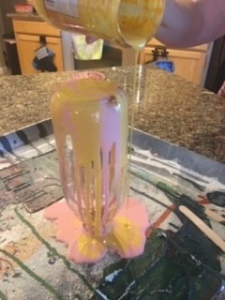 Pouring paint on the bottle.
