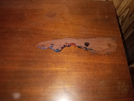 Damage on the top of a set of bedroom furniture.