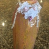 A painted bottle with embellishments.