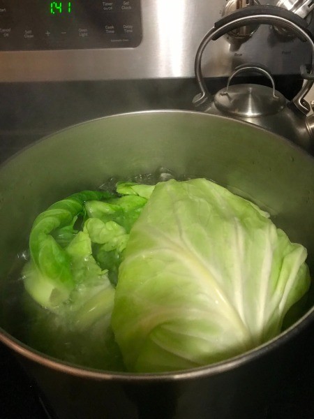Cooking the cabbage leaves in boiling water.