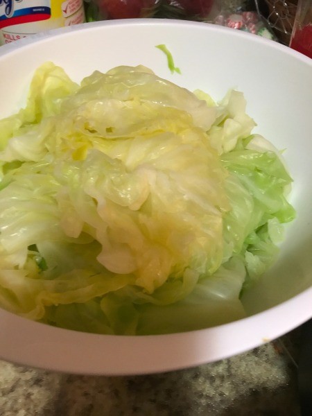 Cooling cooked cabbage leaves in a bowl.