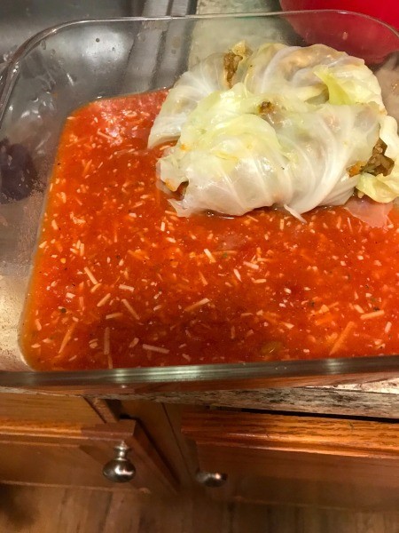 Adding the cabbage rolls to a pan.