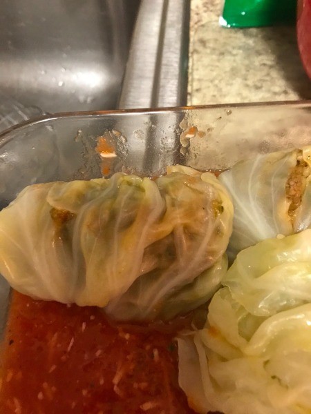 Placing the cabbage rolls in a saucepan.