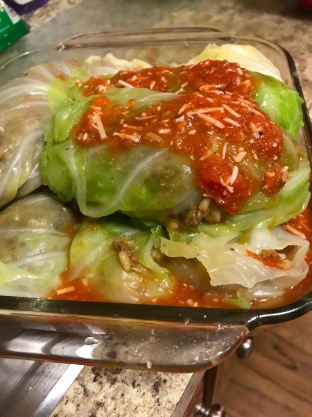 Adding sauce to the cabbage rolls.