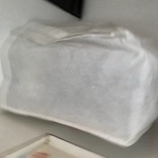 A reusable white shopping bag over a kitchen appliance.