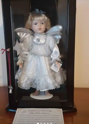 An angel doll in a glass case.