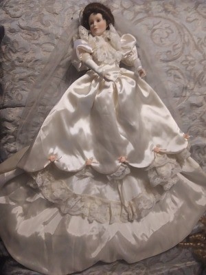 A porcelain doll in a white dress.