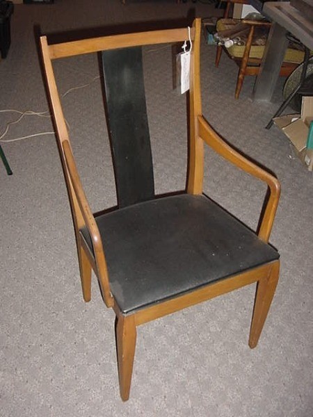 A wooden dining chair with arms.