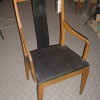 A wooden dining chair with arms.
