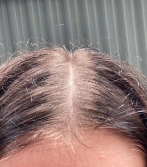 A woman hair with lighter roots.