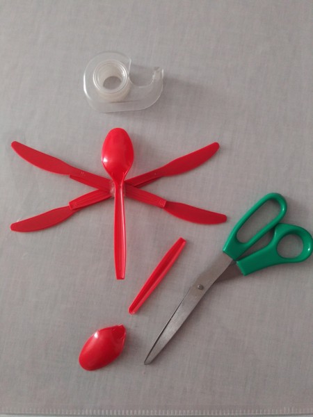 Cutting the head off a plastic spoon.