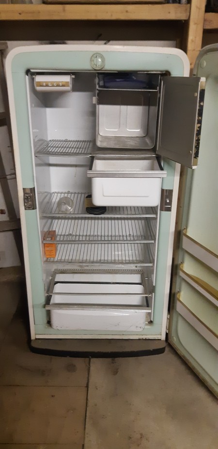 An old white refrigerator with both doors open.