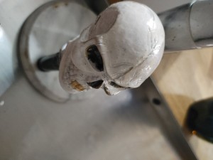 A stick shift knob that resembles a skull.