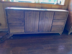 A wooden credenza with doors and drawers.
