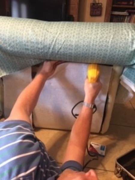 Attaching new upholstery to a chaise lounge.