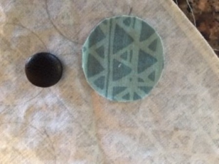 Recovering buttons with fabric.