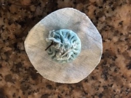 Recovering buttons with fabric.