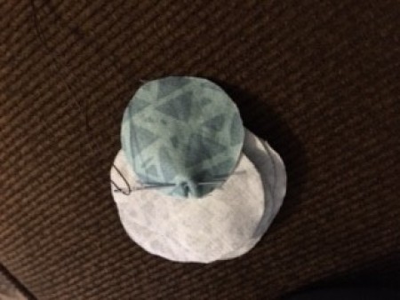 Recovering buttons with fabric.