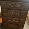A chest of drawers with ornate metal handles.