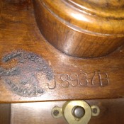 A maker's mark on the bottom of a tilt top tripod table.