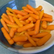 A side dish of carrots in a shallow bowl.
