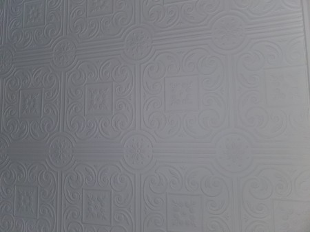 Patterned white ceiling paper in an ornate design.