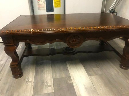 A coffee table with carvings on the side.