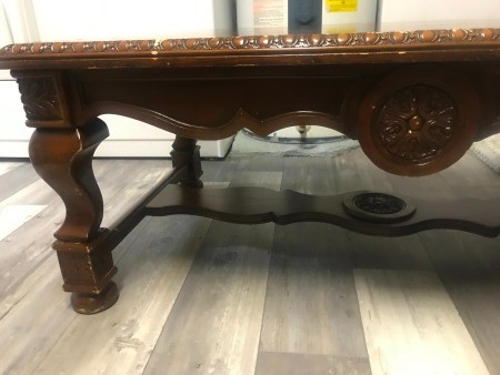 A coffee table with carvings on the side.