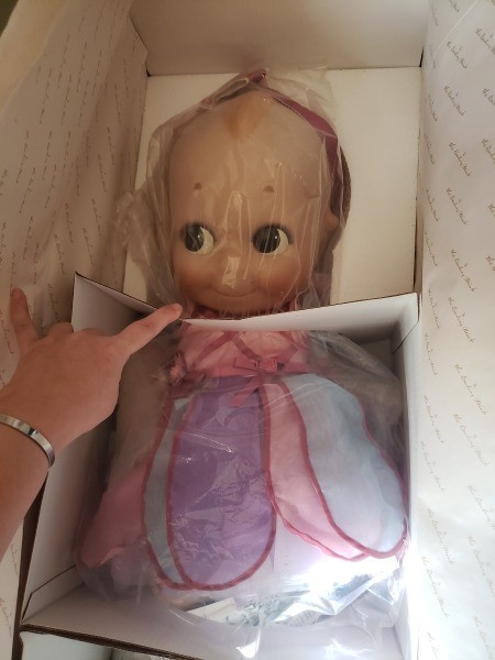 A Kewpie doll still in the packaging.