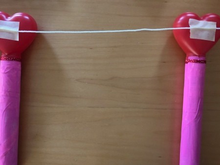 Attaching string to the tops of the valentine tubes.