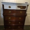 A chest of drawers with the top drawer painted partly white.