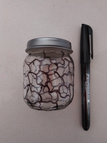Jagged lines drawn on a recycled baby jar.