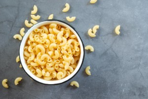 A bowl of uncooked macaroni noodles.